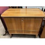 A mid-20th century teak drinks cabinet with a drop down front with a preparation surface,