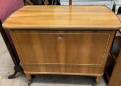 A mid-20th century teak drinks cabinet with a drop down front with a preparation surface,