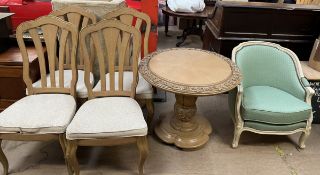 A carved modern dining table and four chairs together with an upholstered arm chair