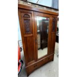 An Edwardian walnut single door wardrobe with a base drawer on bracket feet