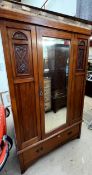 An Edwardian walnut single door wardrobe with a base drawer on bracket feet