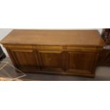 A 20th century sideboard with a rectangular top above three drawers and three cupboards on bracket