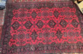 A large red ground rug, with three lines of six medallions to multiple guard stripes,