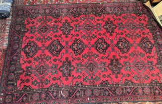 A large red ground rug, with three lines of six medallions to multiple guard stripes,
