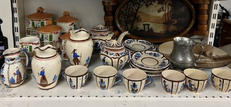 A Quimper part tea service together with a pottery plate painted with a landscape scene,