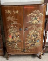 A Chinoiserie decorated drinks cabinet with hinged doors enclosing bottle compartments and shelves