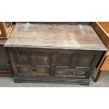 A 20th century oak coffer with a planked top and panelled front with drawers on bracket feet