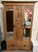 An Edwardian satin walnut wardrobe with a moulded cornice above a pair of mirrored doors and a