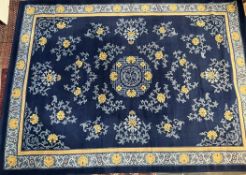 A Chinese rug with a blue ground with multiple flowerheads,