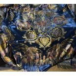 A bed spread decorated with Arabic figures, camels, palm trees,