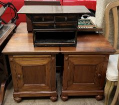 A pair of hardwood bedside cabinets with square tops above a slide and door on turned feet together