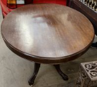 A Victorian mahogany supper table with an oval top above four turned columns and outswept feet