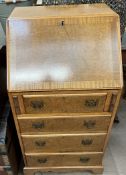 A 20th century walnut bureau with a sloping fall and four drawers