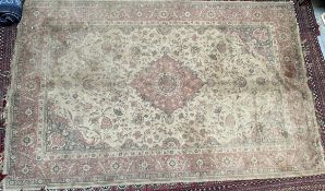 A rug with a cream ground and central medallion,