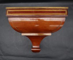 An Edwardian mahogany and brass inlaid clock wall bracket with a rectangular top and caddy shaped