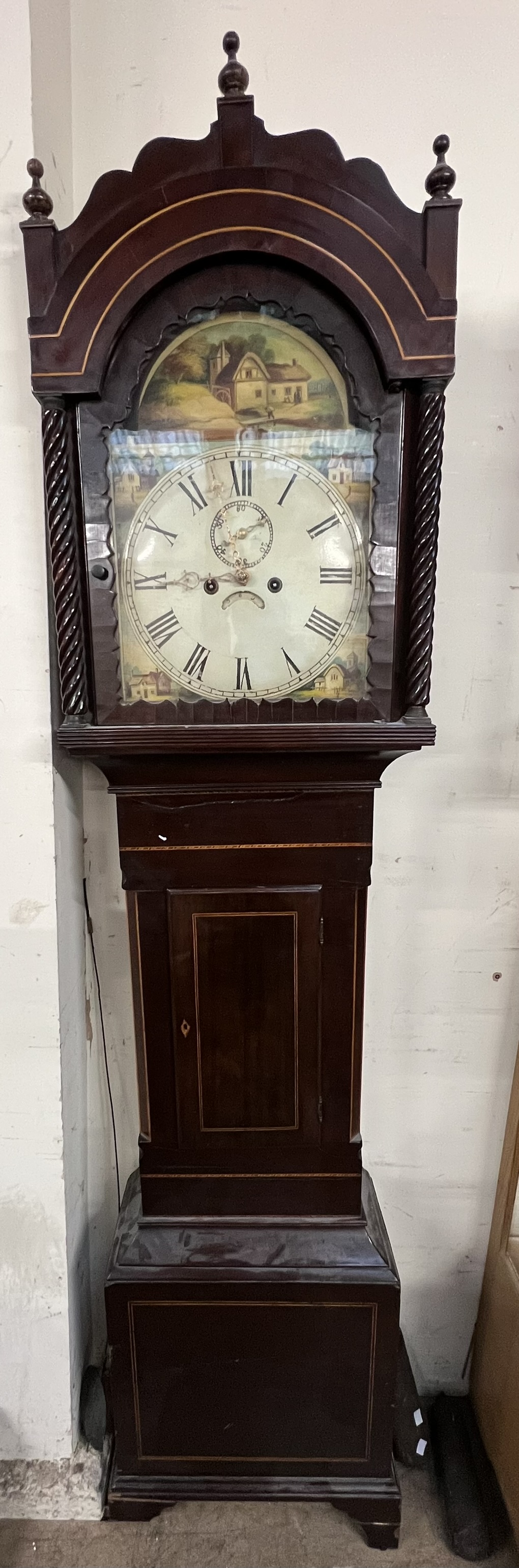 A 19th century mahogany longcase clock with a domed hood and rope twist columns above a short trunk