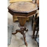 A Victorian walnut work table with a carved octagonal top above a tapering body and three carved