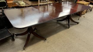 A Regency style mahogany twin pedestal dining table with two leaves,