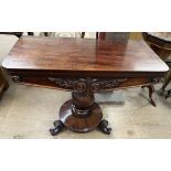 A 19th century mahogany carved table with foldover top and baize interior with a carved front on a