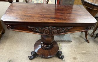 A 19th century mahogany carved table with foldover top and baize interior with a carved front on a