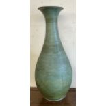 A large pottery baluster vase with a green glaze and brown interior