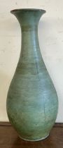 A large pottery baluster vase with a green glaze and brown interior