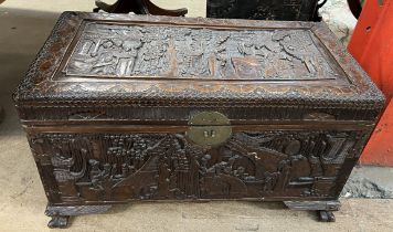A carved Chinese camphorwood coffer decorated with figures and trees