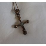 A silver and moonstone cross on a silver chain,
