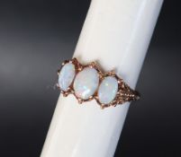 A 9ct yellow gold three stone opal ring, size O,