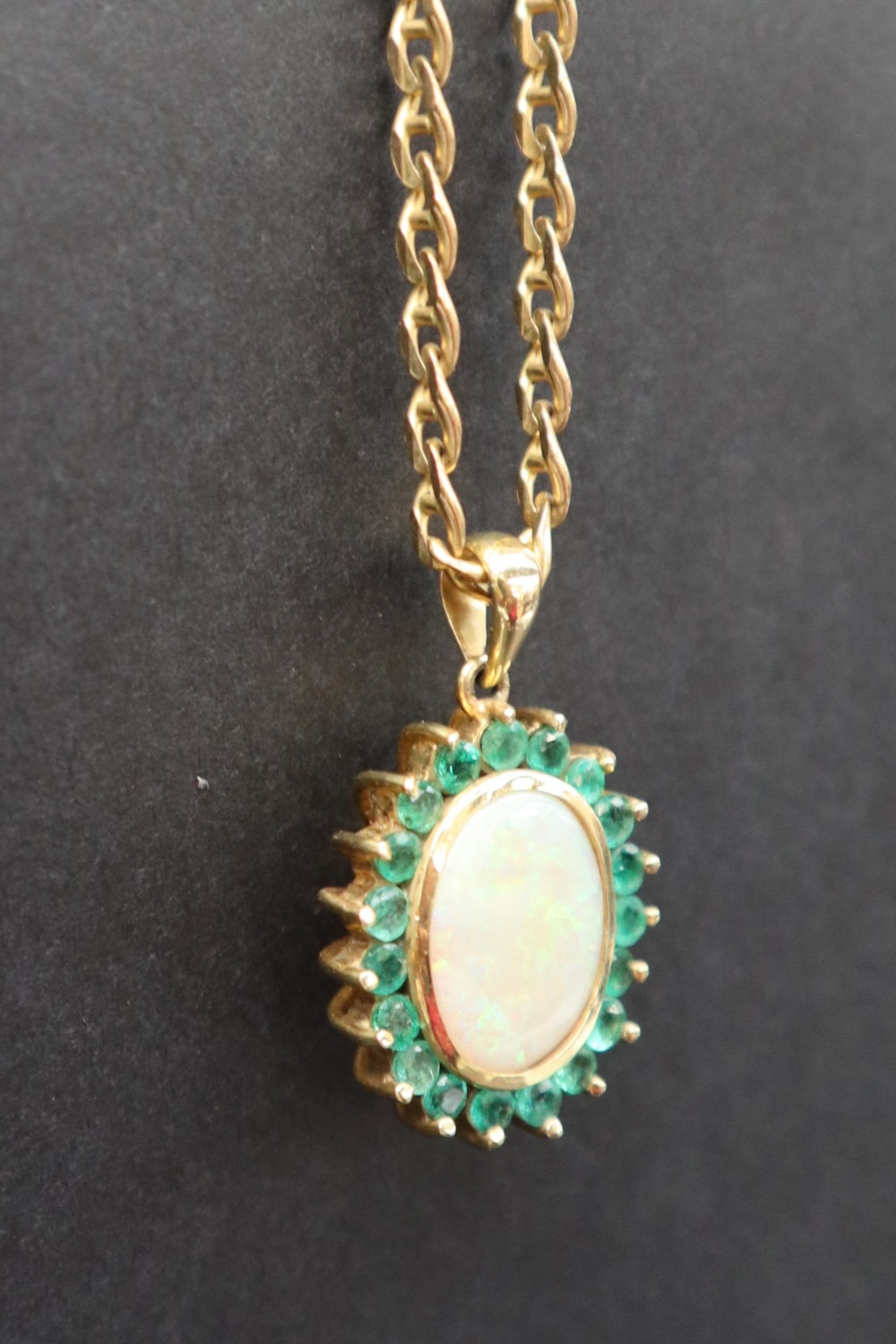 An emerald and opal pendant of oval form set with a central opal and nineteen emeralds to yellow - Image 4 of 9
