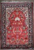 A Quo rug with a pink ground and central mihrab, with cream spandrels and floral guard stripes,