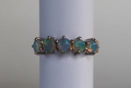 An 18ct yellow gold ring set with five opals, size M,