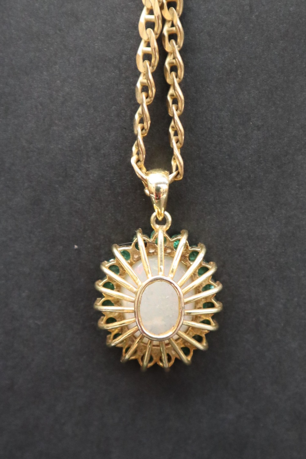 An emerald and opal pendant of oval form set with a central opal and nineteen emeralds to yellow - Image 5 of 9