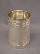 A Victorian silver tankard of tapering cylindrical form, with line decoration and scrolling handle.