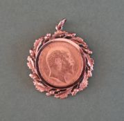 An Edward VII gold sovereign dated 1910 in a 9ct gold acorn and oak leaf slip mount,