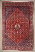 A red ground Bijar rug, with central diamond shaped medallions with multiple guards stripes,