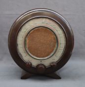 An Ekco type A22 radio with a circular bakelite case with three dials,