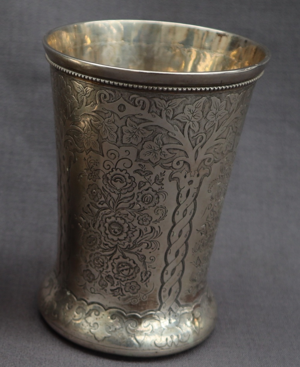 A 19th century Russian silver beaker, of tapering form with a spreading foot decorated with trees,