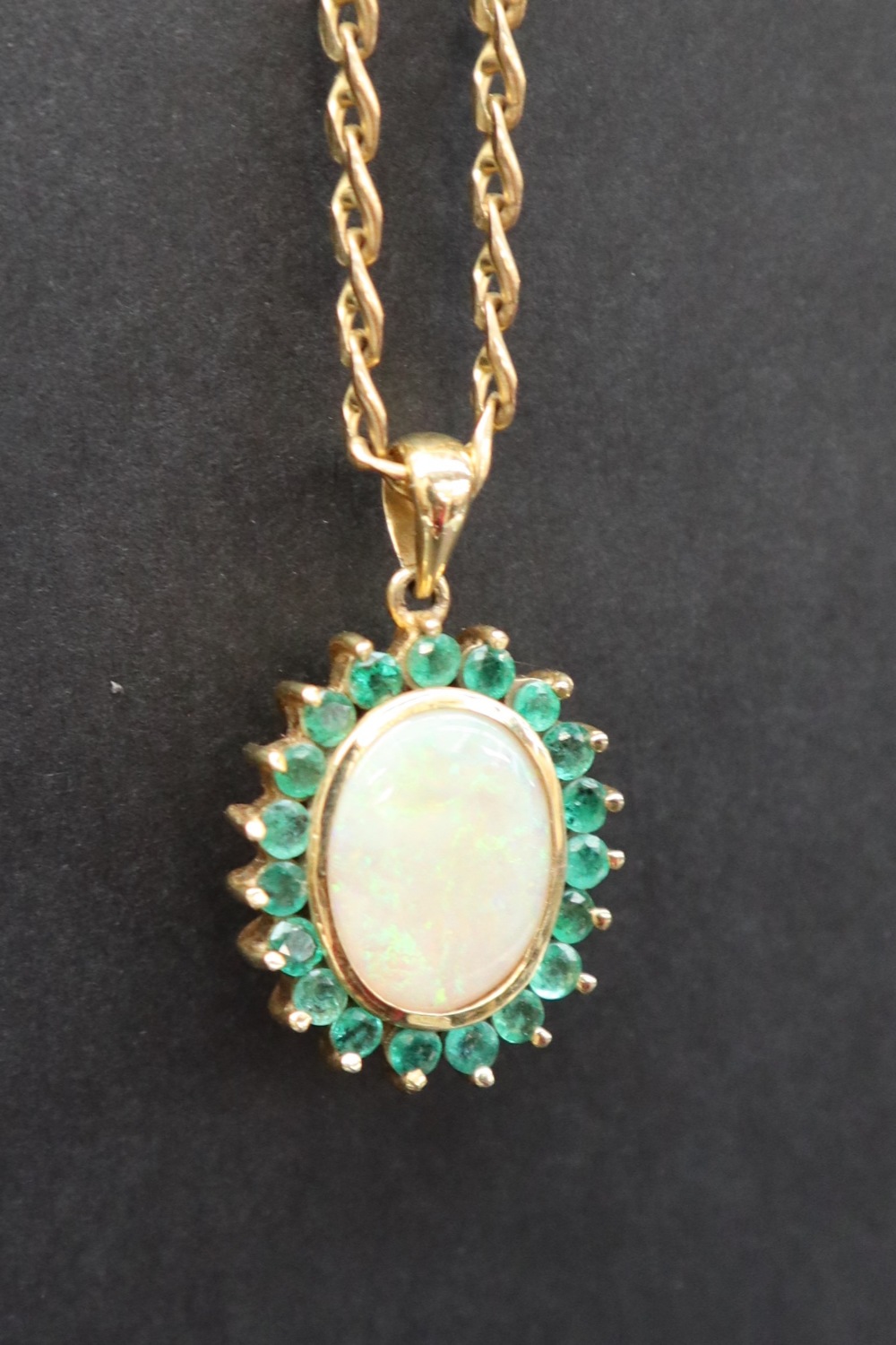 An emerald and opal pendant of oval form set with a central opal and nineteen emeralds to yellow - Image 3 of 9