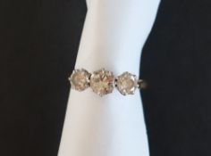 A three stone diamond ring, set with round brilliant cut diamonds,