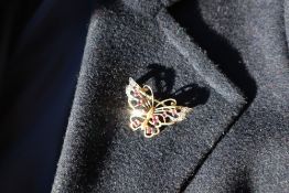 A 9ct yellow gold brooch in the form of a butterfly set with eight rubies and eight diamonds,