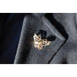 A 9ct yellow gold brooch in the form of a butterfly set with eight rubies and eight diamonds,