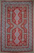 A red ground rug, with pale blue lines and flower heads, to multiple guard stripes,