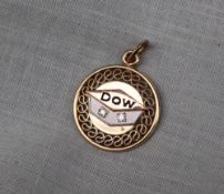 A yellow metal pendant set with two diamonds and black enamel D O W approximately 3.