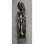 An African carving of a seated figure with his head resting on his right hand on a square plinth,