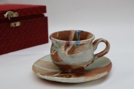 Attributed to Kawai Kanjiro, tea cup and saucer decorated in greens, blues and reds,