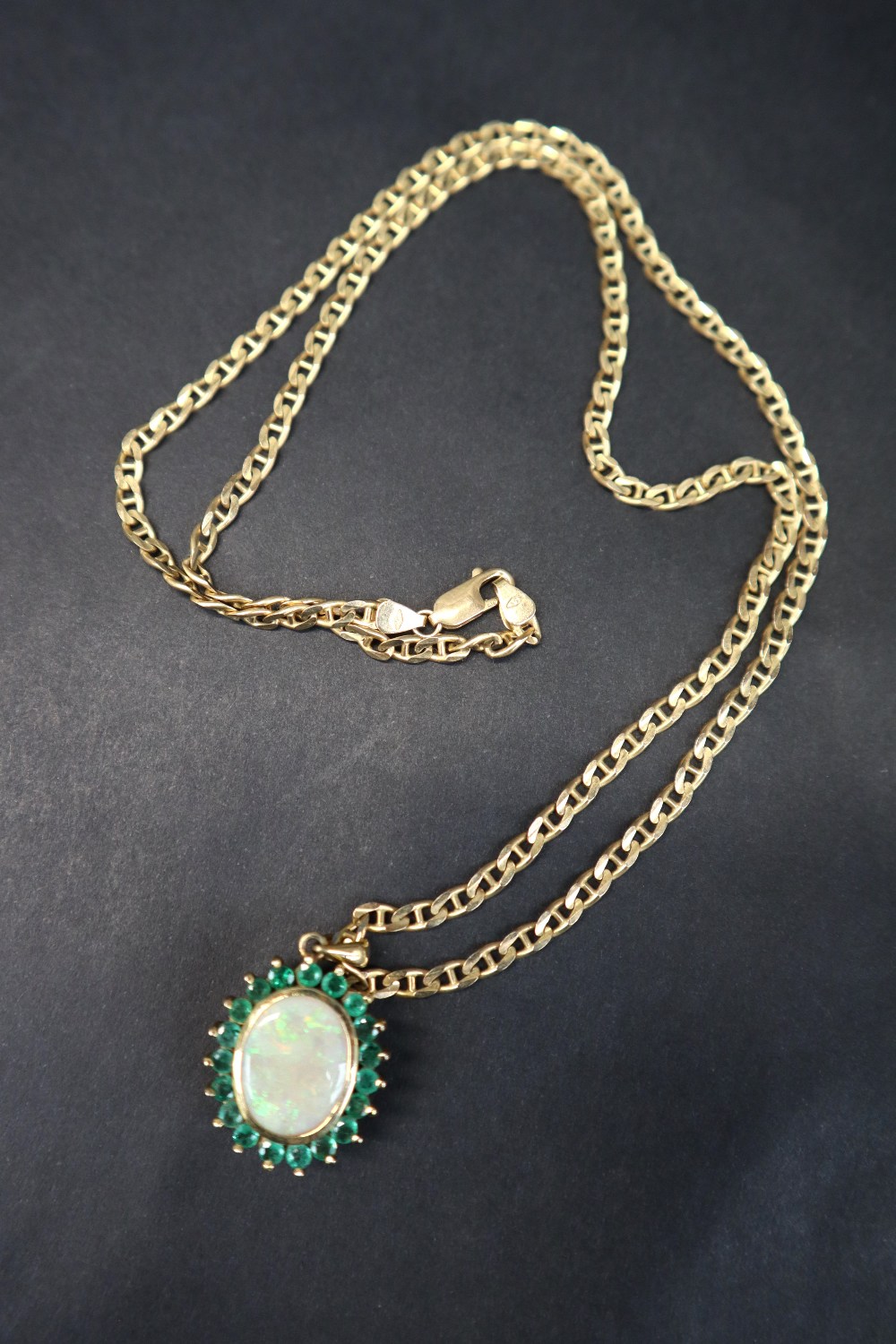 An emerald and opal pendant of oval form set with a central opal and nineteen emeralds to yellow - Image 7 of 9