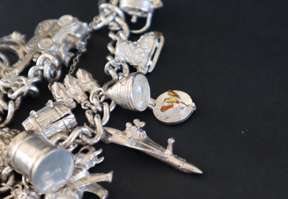 A white metal charm bracelet set with numerous charms including, a guitar, a car, a swan, shell, - Image 4 of 5