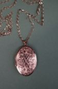 A 9ct yellow gold locket of oval form, decorated with scrolls and leaves on a 9ct gold chain,