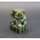 A Chinese hardstone dog of foo figure, seated on a platform,